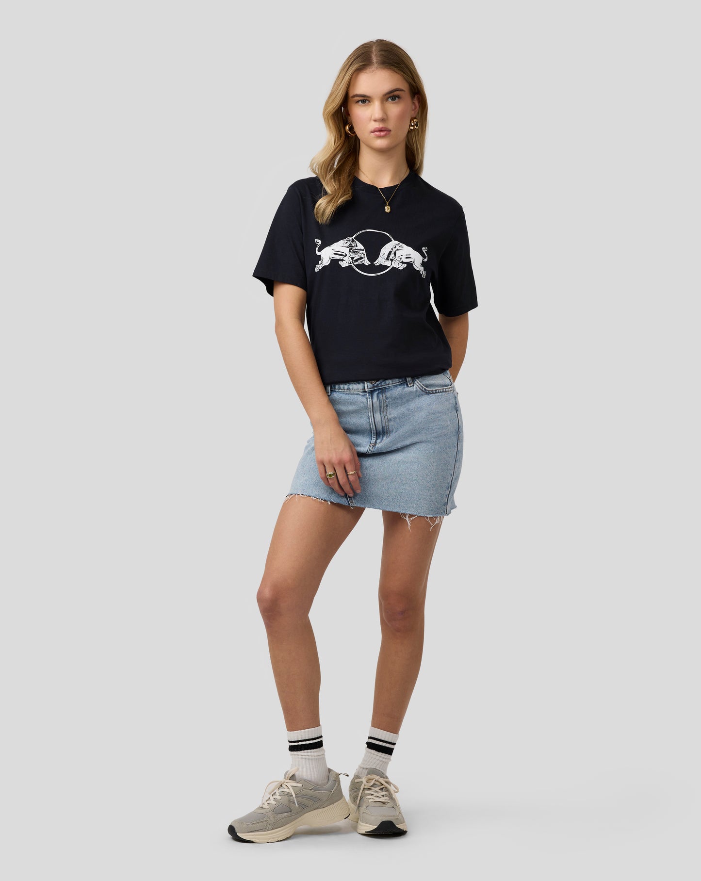 Female model in a black Oracle Red Bull Racing graphic bull T shirt with a white emblem centered on the chest.