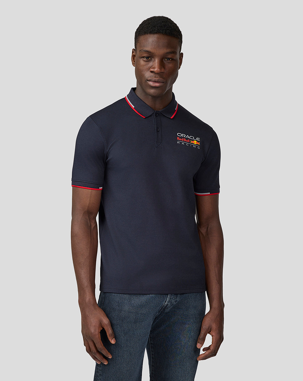 Model wearing navy Oracle Red Bull Racing Core Polo with chest logo and red tipping on collar and sleeves.