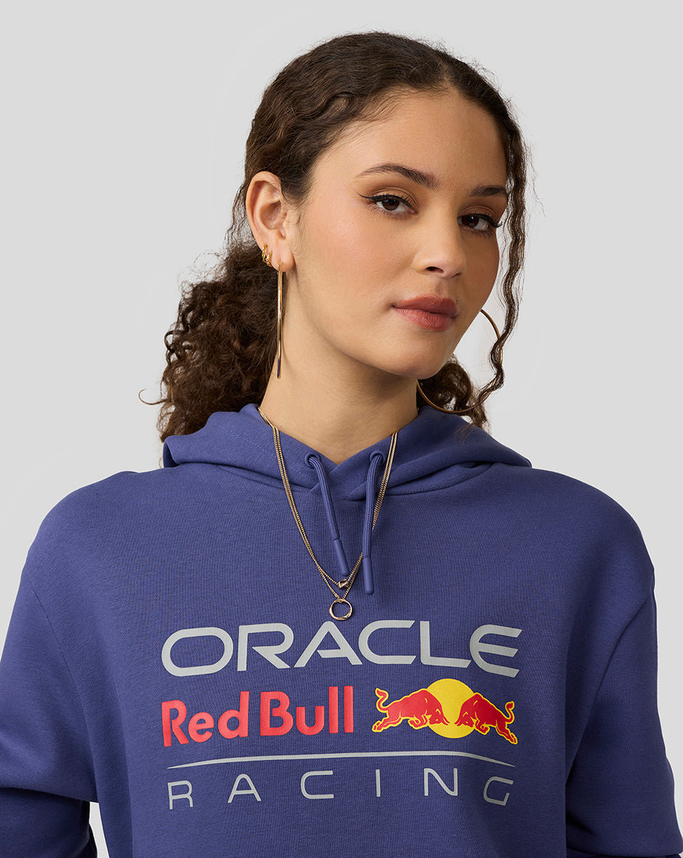 Woman in Skipper Blue Oracle Red Bull Racing hoodie showing large front logo.
