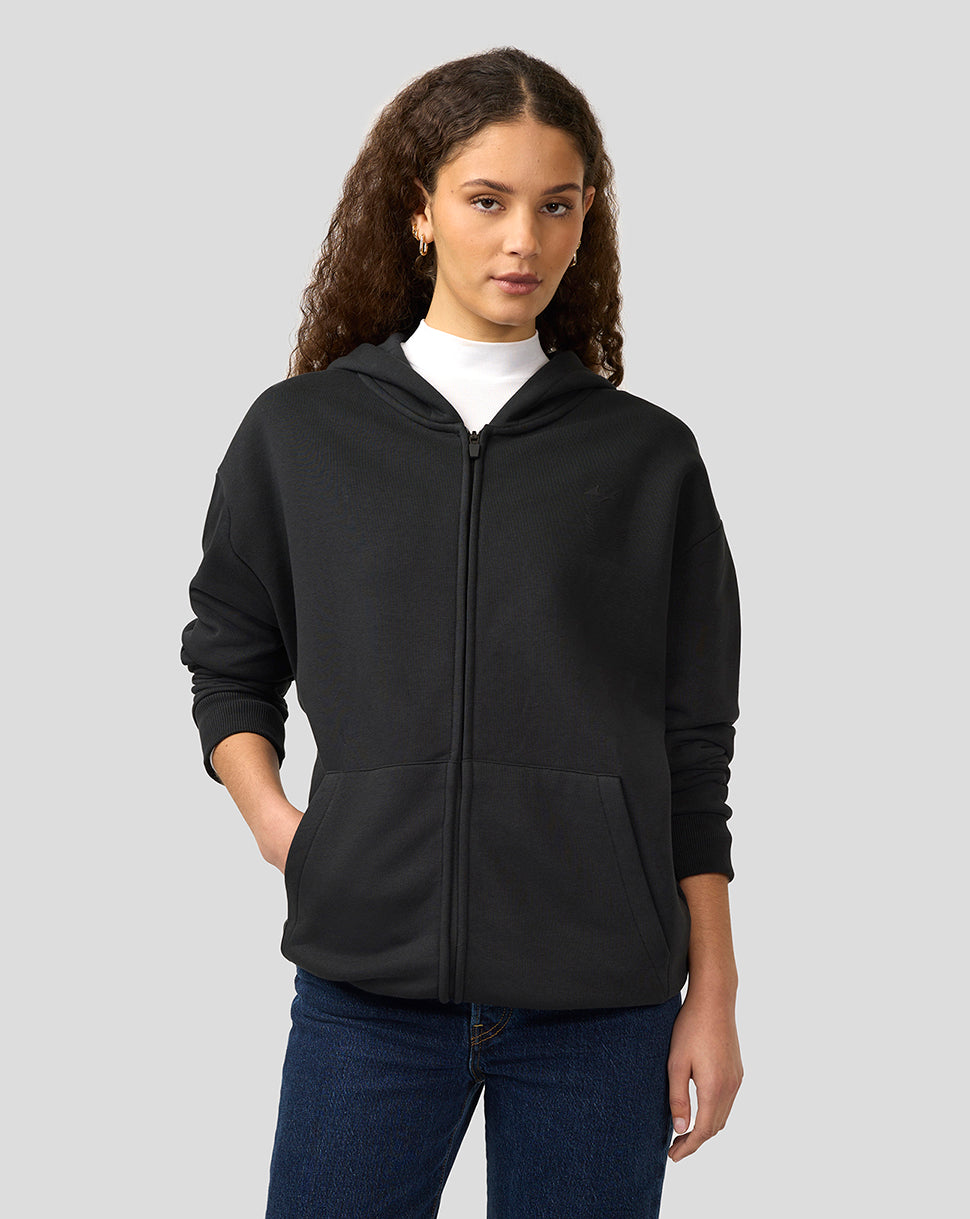Female model wearing oversized black dual brand zip hoodie with front pockets and hood.