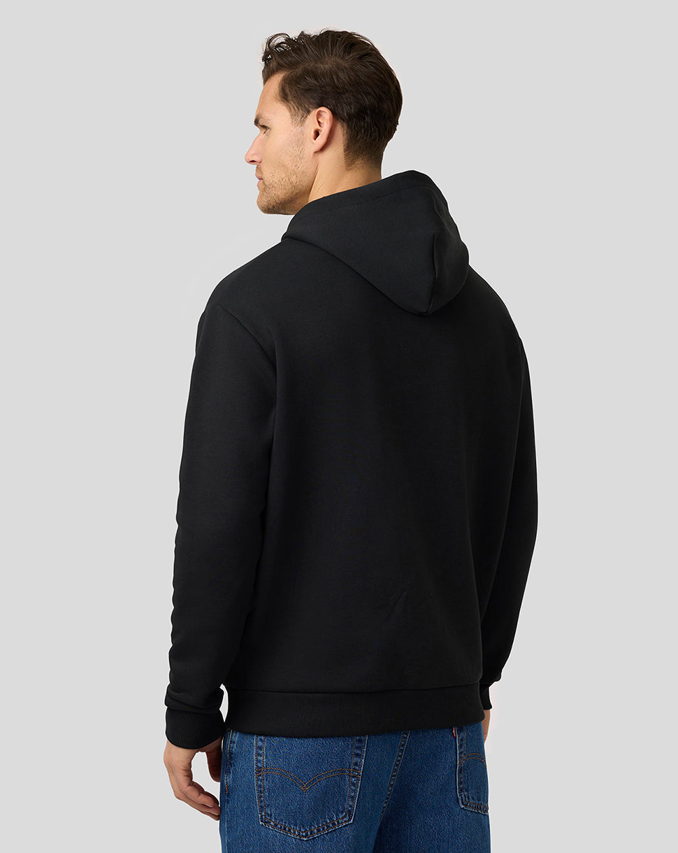 Back view of a person wearing a black zip hoodie with hood and ribbed hem.