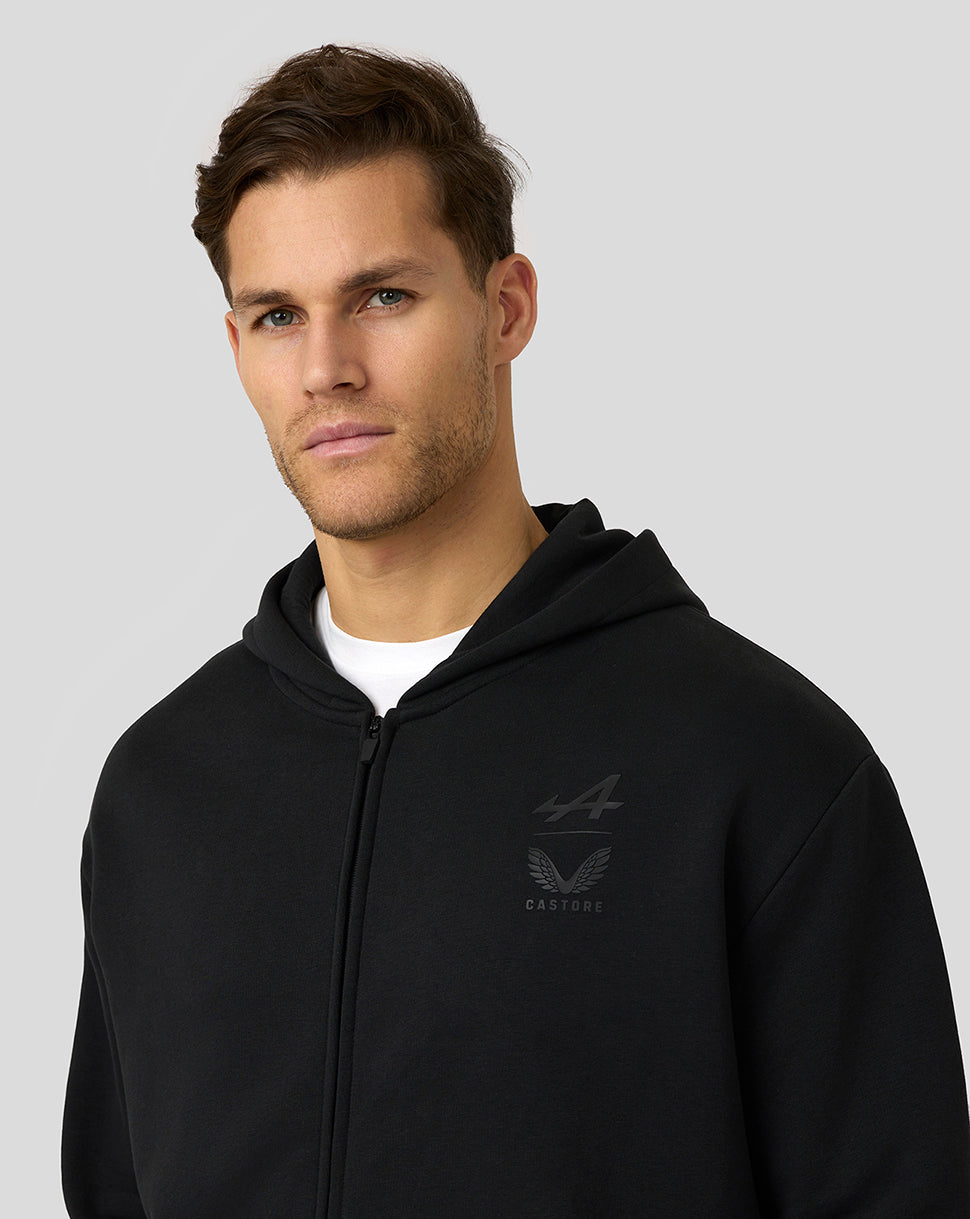 Close up of a man in a black zip hoodie with a small chest logo