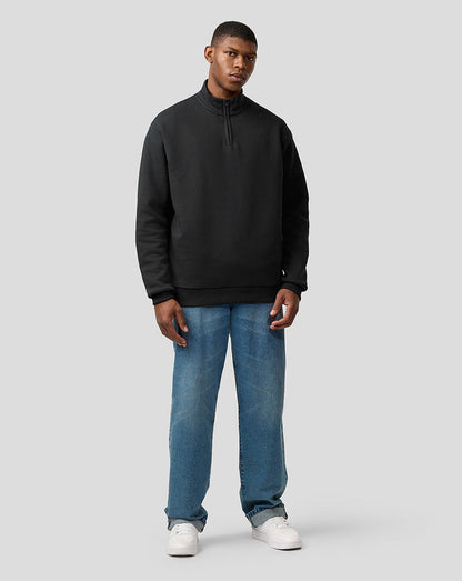 Front view of a man wearing a black quarter zip pullover with a stand up collar.