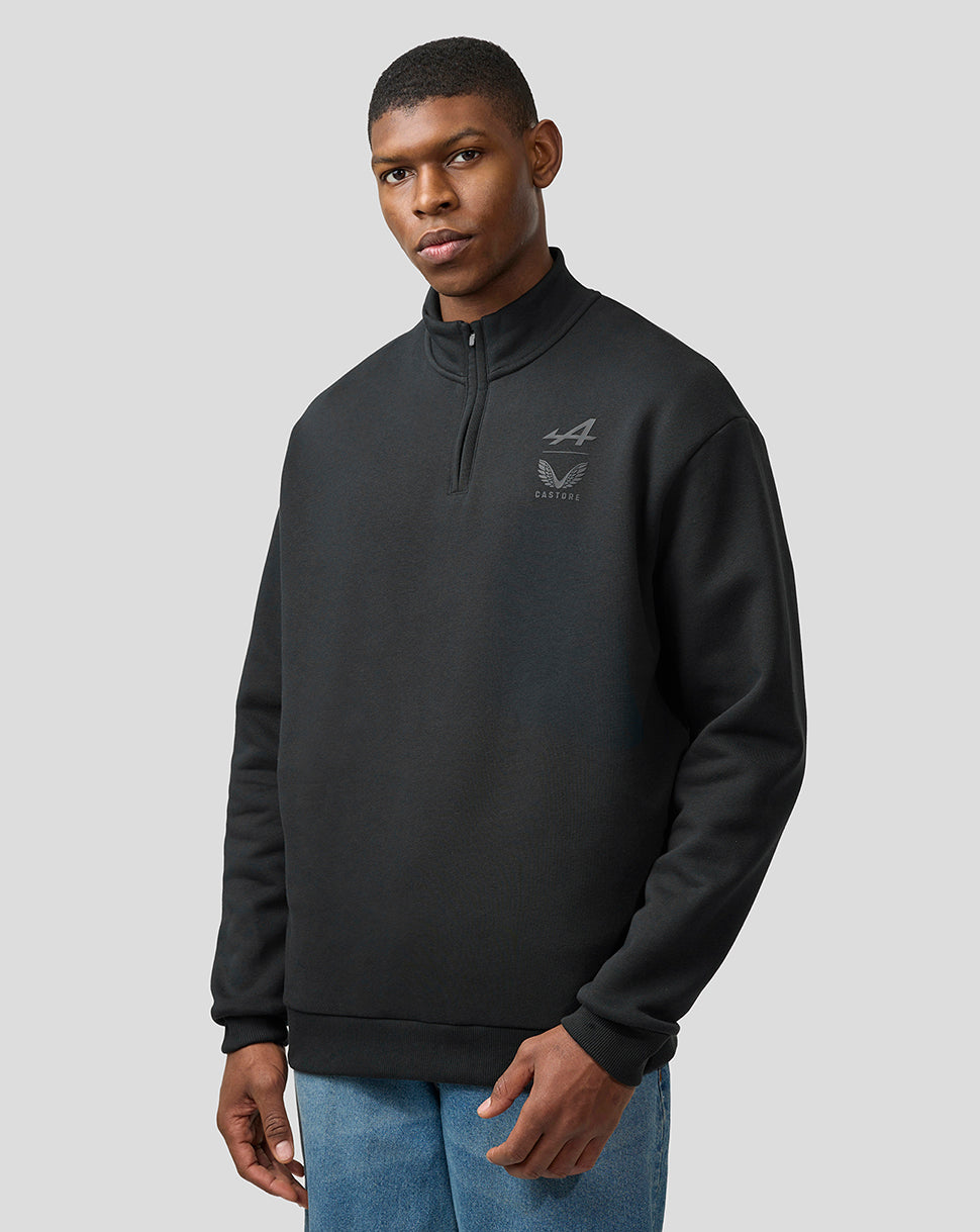 Male model wearing black quarter zip fleece with high collar and chest Alpine Castore logos showcasing a relaxed fit