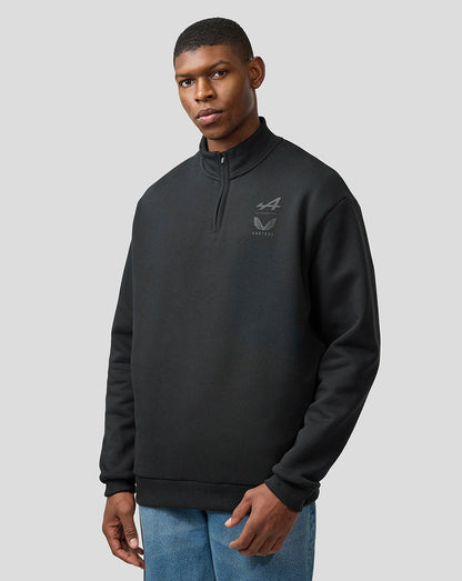 Male model wearing black quarter zip fleece with high collar and chest Alpine Castore logos showcasing a relaxed fit