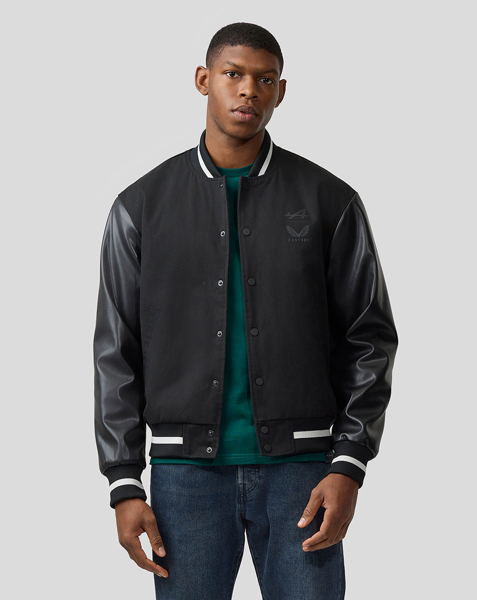 Male model in black varsity style bomber jacket with leather sleeves and striped cuffs
