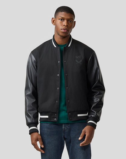 Male model in black varsity style bomber jacket with leather sleeves and striped cuffs