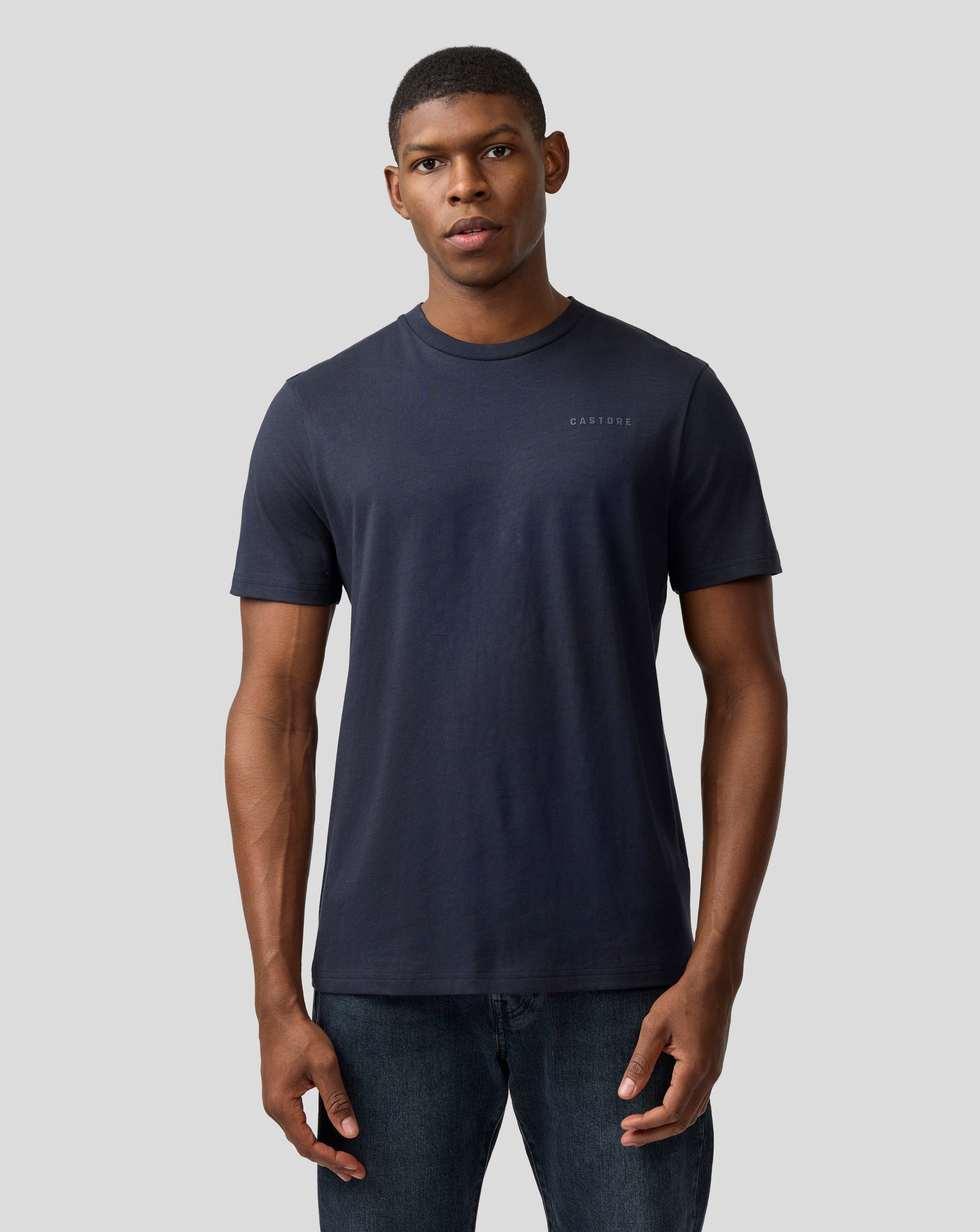 Man in a night sky navy Castore regular fit T shirt with small chest logo.