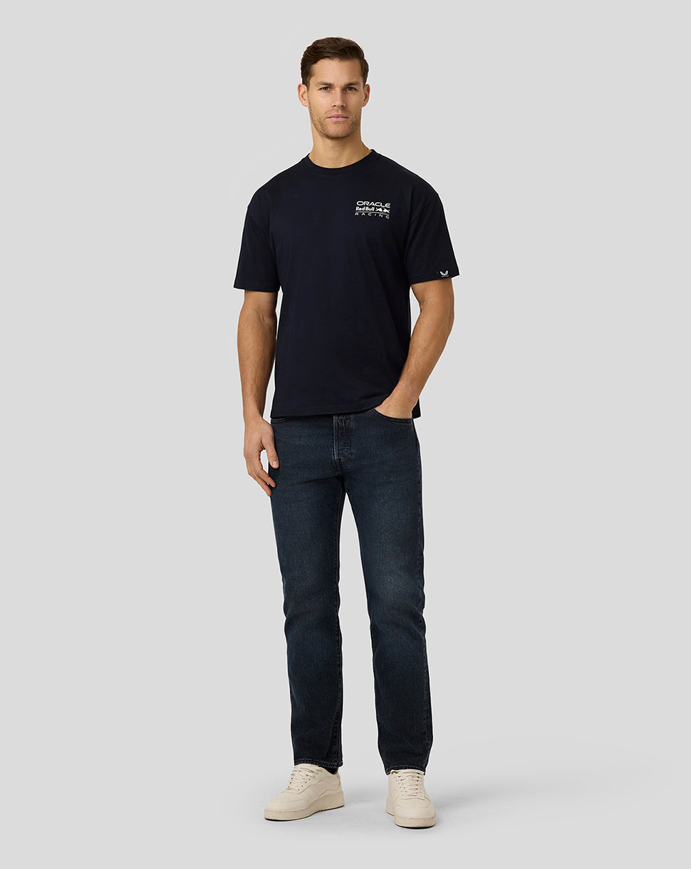 Full body shot of a man in a navy Oracle Red Bull Racing T shirt with a small white chest logo.
