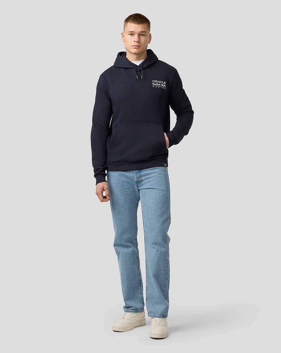 Full-body view of a model wearing a night sky hoodie with a front crest, paired with blue jeans and beige sneakers.