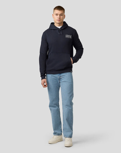 Full-body view of a model wearing a night sky hoodie with a front crest, paired with blue jeans and beige sneakers.