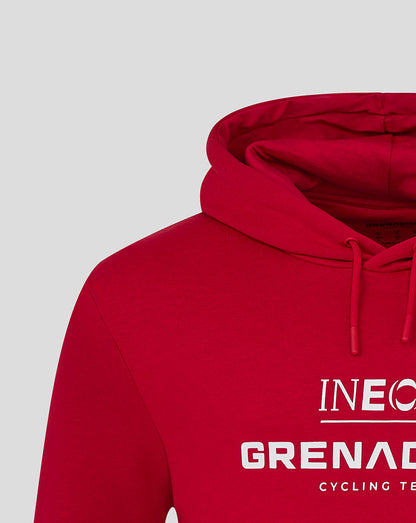 Close-up of red hooded sweatshirt showing INEOS Grenadiers logo on the chest and drawstring hood.