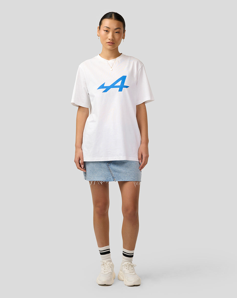 Front view of Alpine Unisex Core Essentials T-Shirt in Brilliant White with bold blue logo on the chest worn by a model in a denim skirt