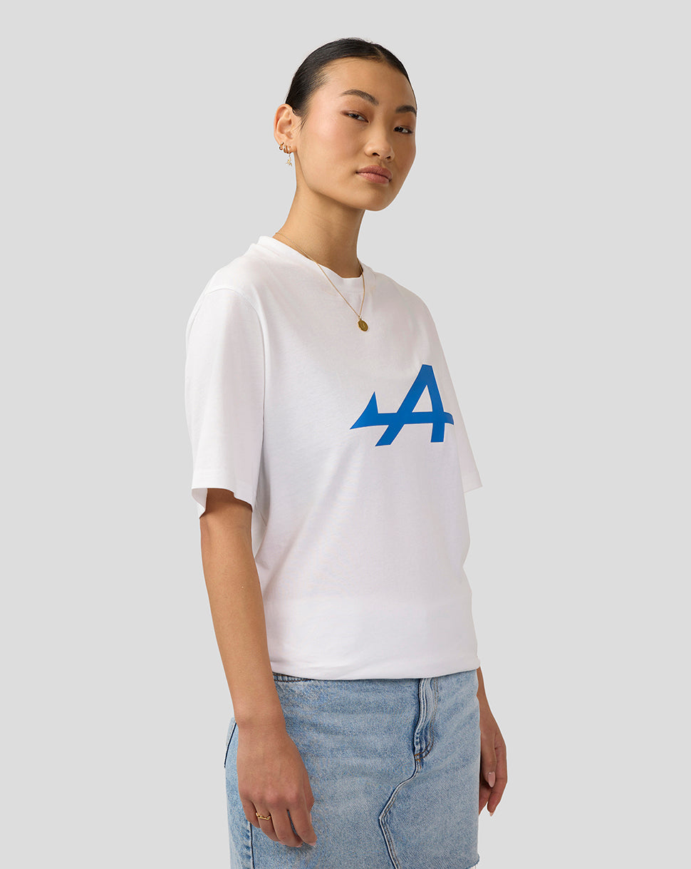 Female model in a brilliant white Alpine Core Essentials T-Shirt with a blue chest logo in a three-quarter view.