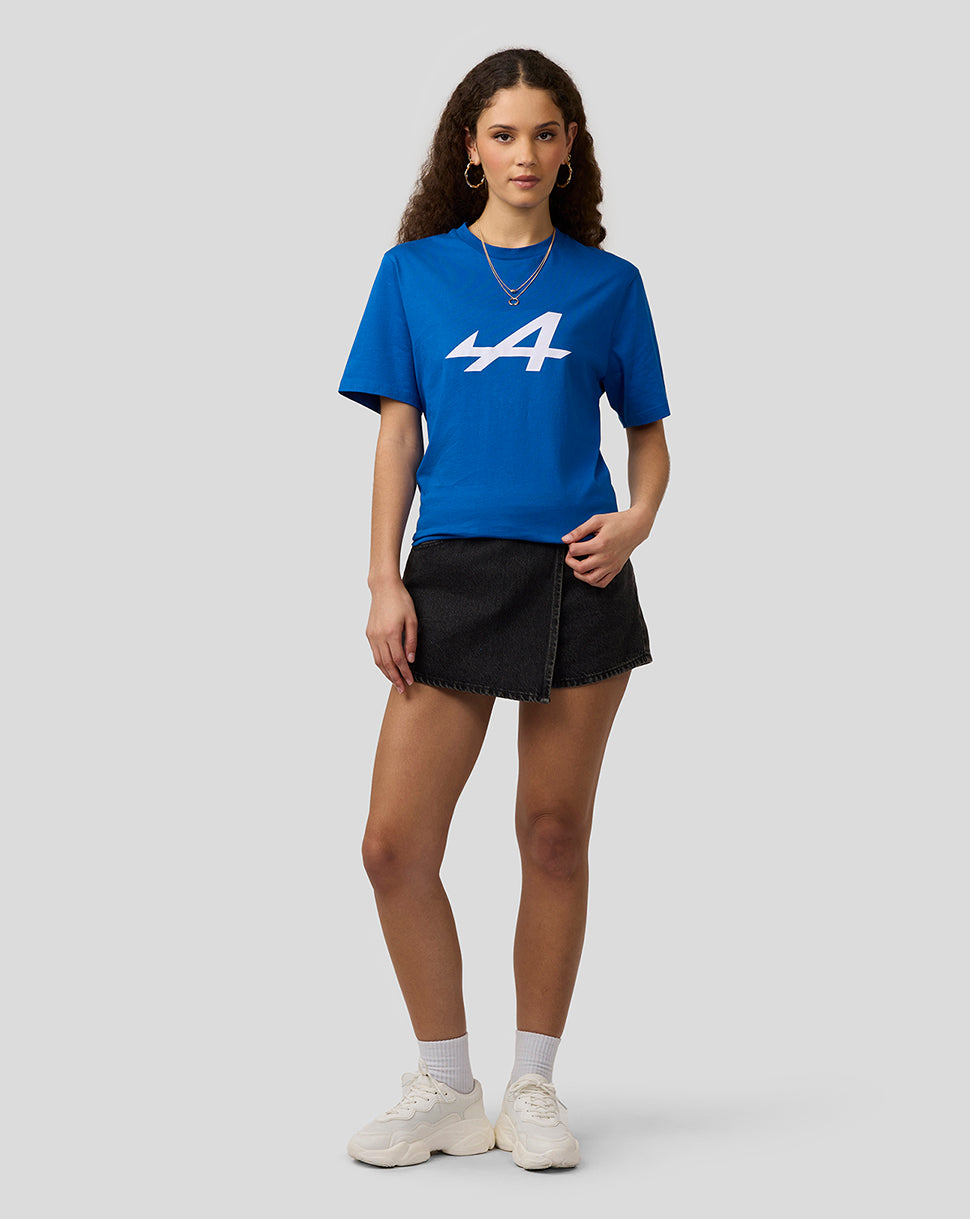 Front view of a woman in a lapis blue Alpine Core Essentials T-shirt with a large white graphic on the chest, paired with a black denim skirt.