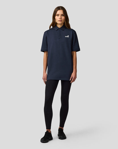 Female model wearing Alpine Unisex Core Essentials Polo Shirt in Black Iris with short sleeves and polo collar.