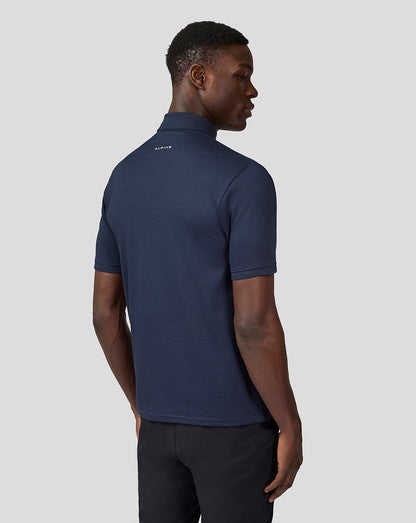 Back view of a man in Alpine Unisex Core Essentials Polo Shirt in Black Iris showing the logo at the back of the neck.