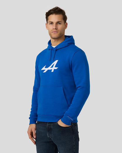 Male model wearing Alpine Core Essentials Hoodie in Lapis Blue with large white logo on the chest and a front pocket.