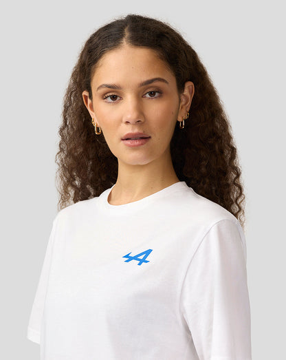 Profile view of a man wearing a white Alpine T-shirt with a small blue logo on the left chest.