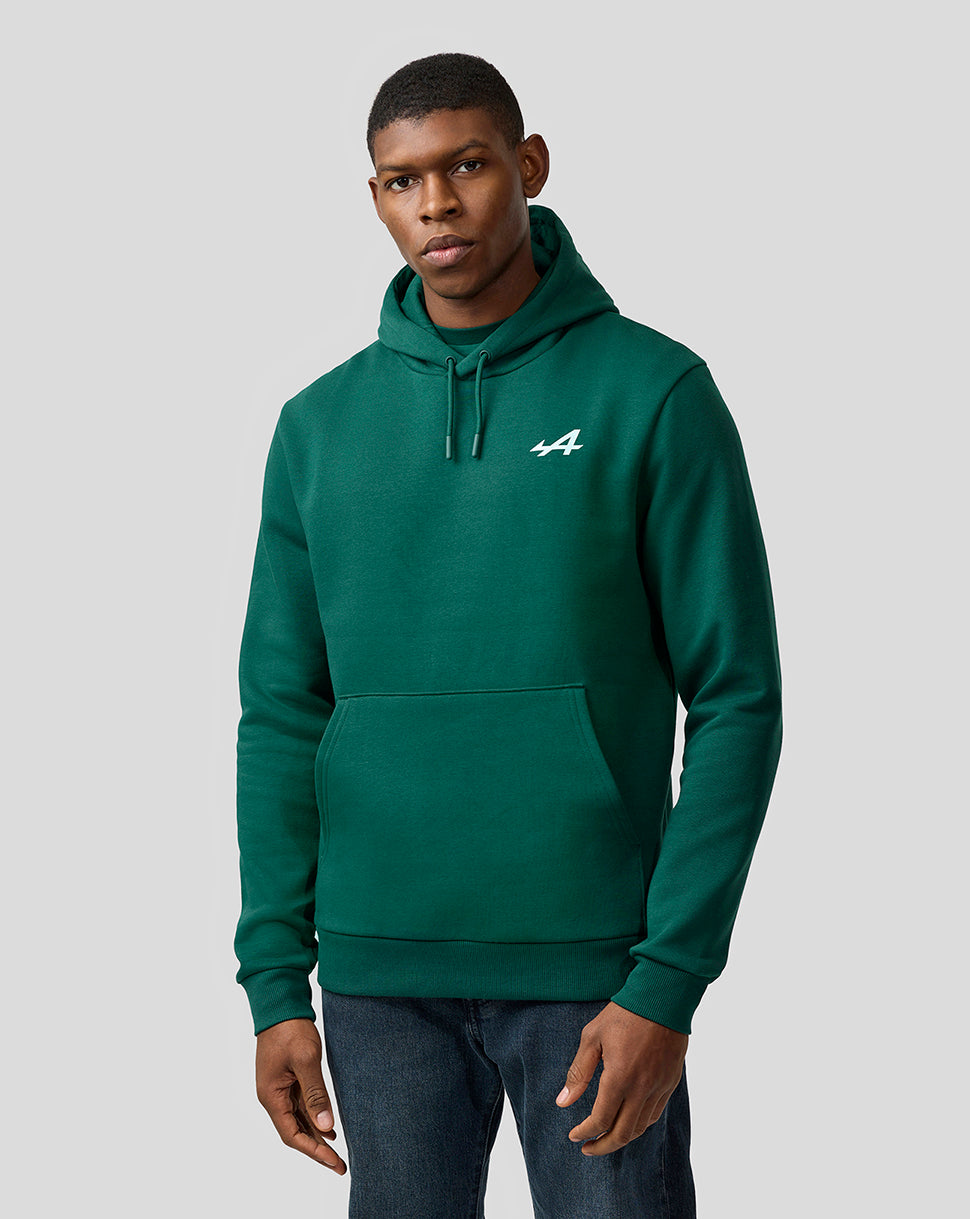 Male model in a botanical green Alpine Unisex Graphic Hoodie with a drawstring hood and front pocket.