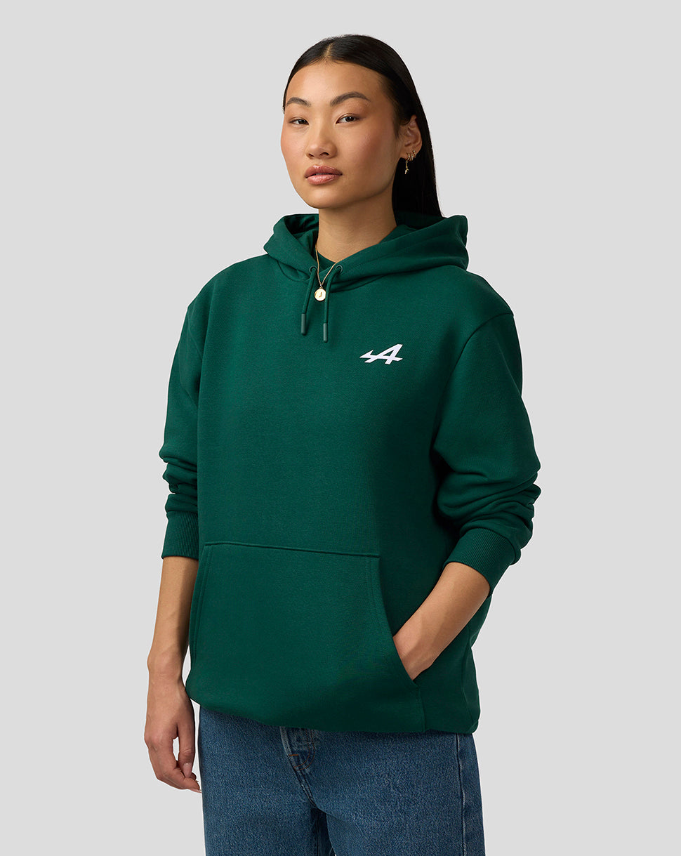 Female model wearing botanical green Alpine unisex graphic hoodie with drawstring hood and front pocket
