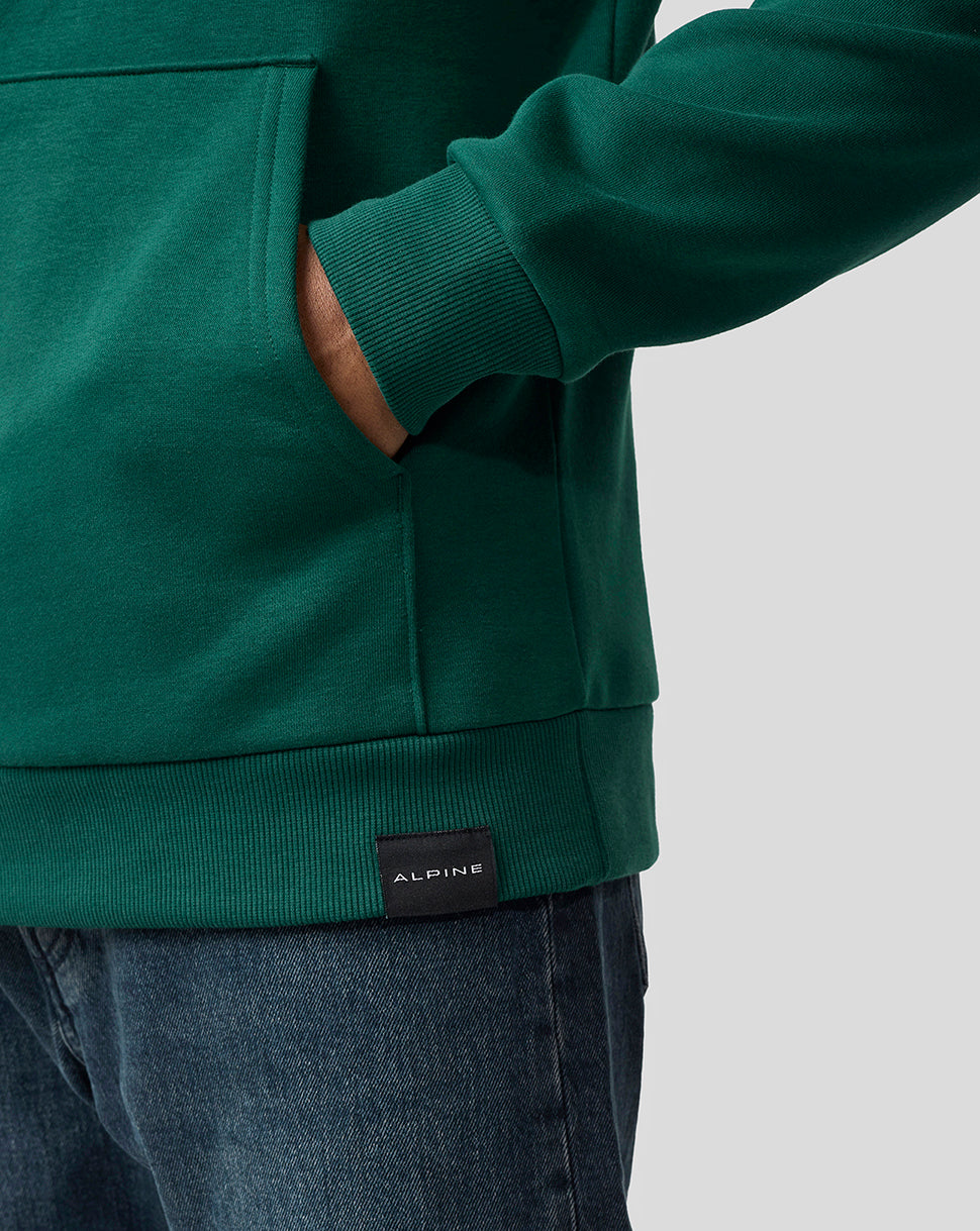 Close up of the green Alpine hoodie cuff and pocket area with a small ALPINE label at the hem.