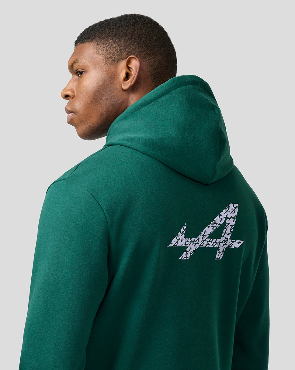 Back view of a person wearing a green Alpine hoodie with a large patterned logo on the back.
