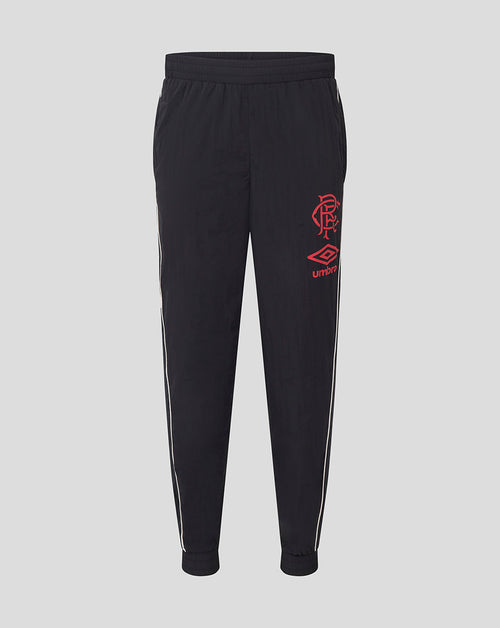 Front view of junior dark travel pants with elastic waistband white piping along the legs and red Rangers crest with Umbro logo.