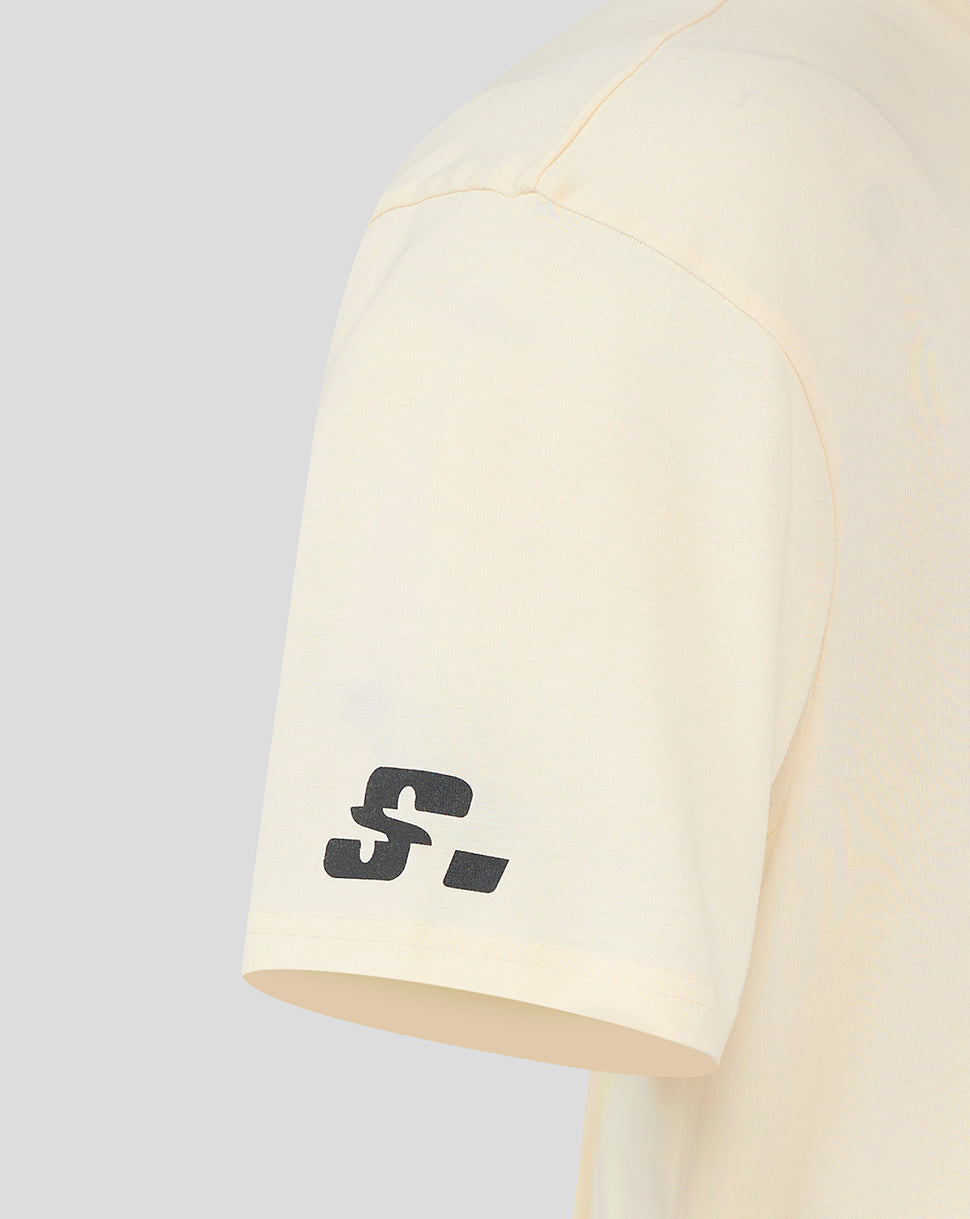 Cream oversized T-shirt sleeve with a small black logo near the hem.