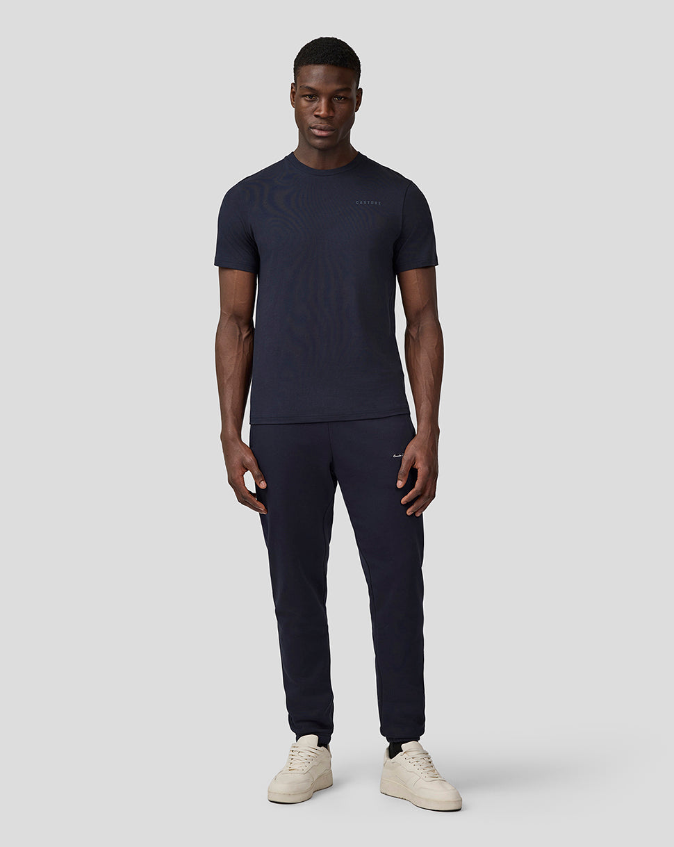 Full-body view of a male model wearing navy Oracle Red Bull Racing heritage joggers with a matching navy T-shirt.