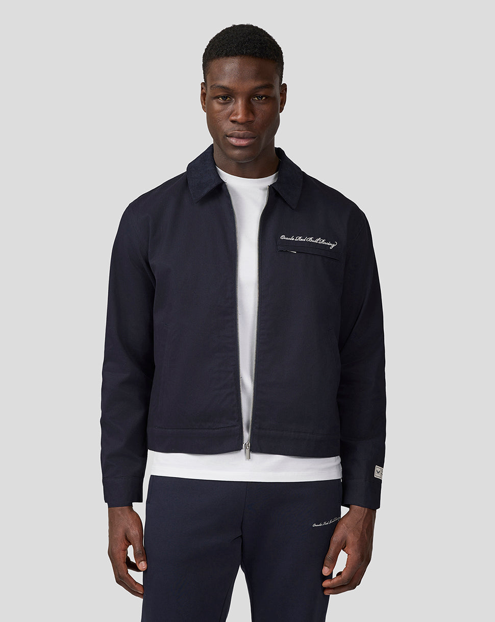 Male model wearing navy cropped Oracle Red Bull Racing script work jacket with front zip and chest embroidery.