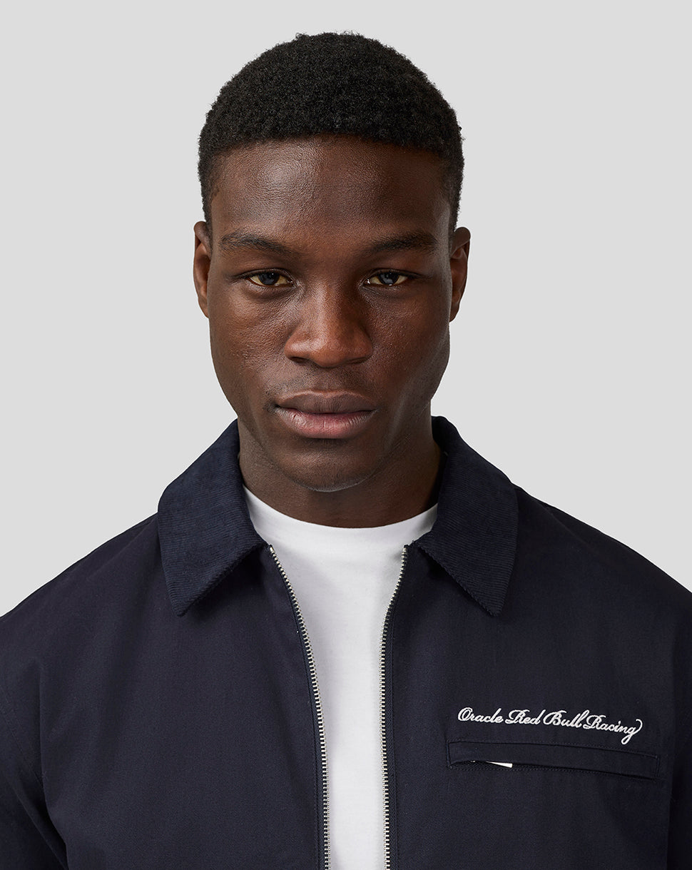 Male model wearing navy Oracle Red Bull Racing script work jacket with zip front and white T-shirt underneath