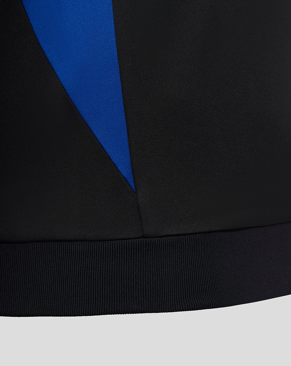 Close-up of the lower side showing a blue angular panel against black fabric and ribbed hem