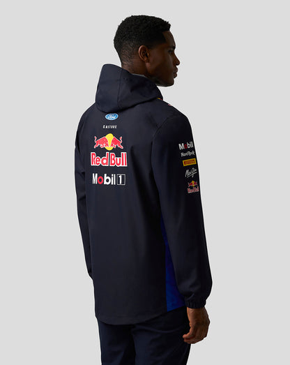 Back view of model in dark navy Red Bull Teamline jacket with prominent Red Bull and sponsor logos on the back.