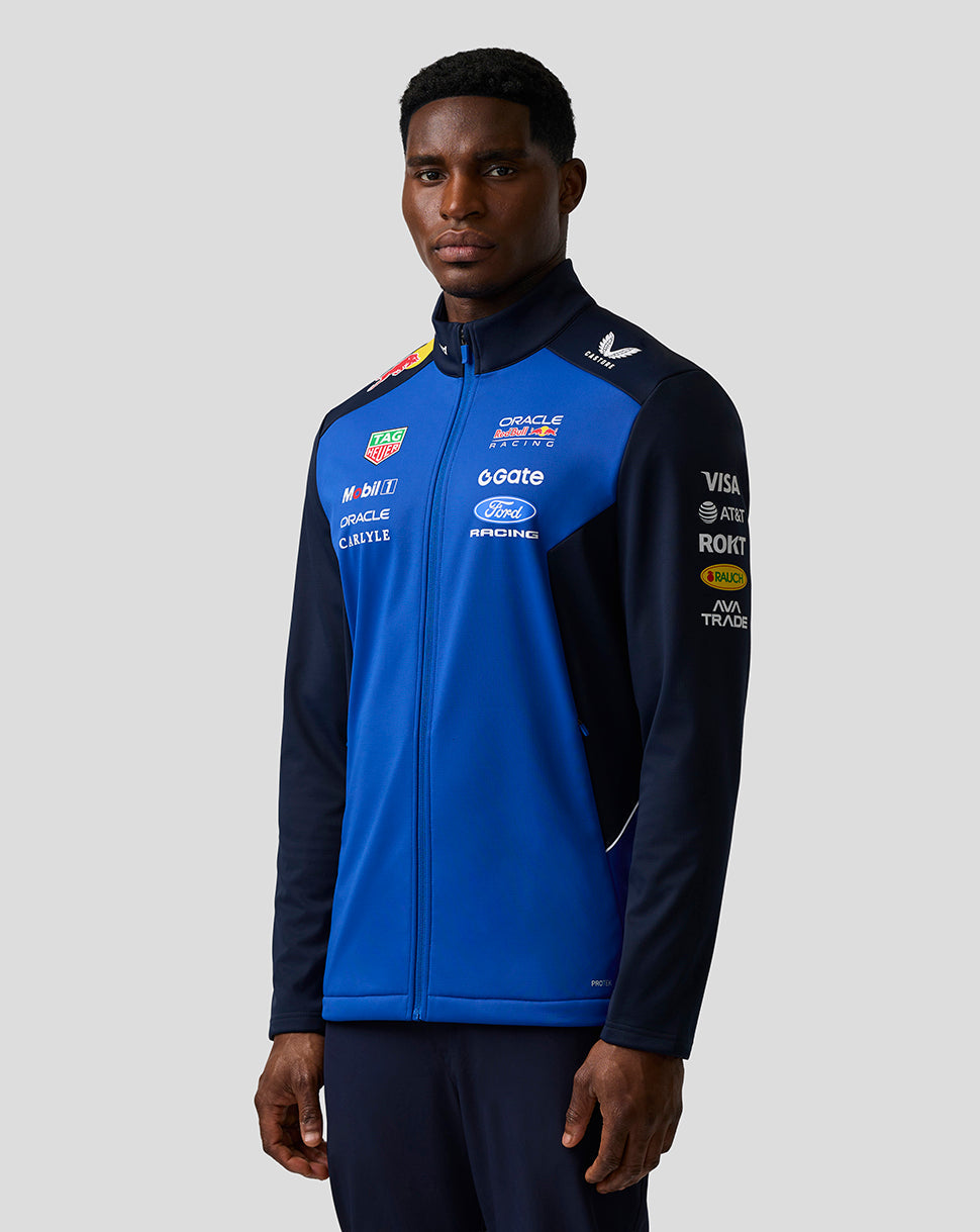 Model wearing Oracle Red Bull Racing Teamline Soft Shell Jacket in night sky blue with navy sleeves and branding