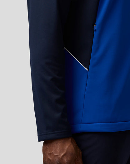 Close up of the Teamline jacket showing the navy sleeve and blue body with a side panel and white piping detail.