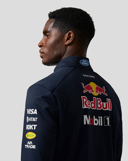Profile view of a man in navy Oracle Red Bull Racing Teamline jacket with sponsor logos on chest and sleeve.