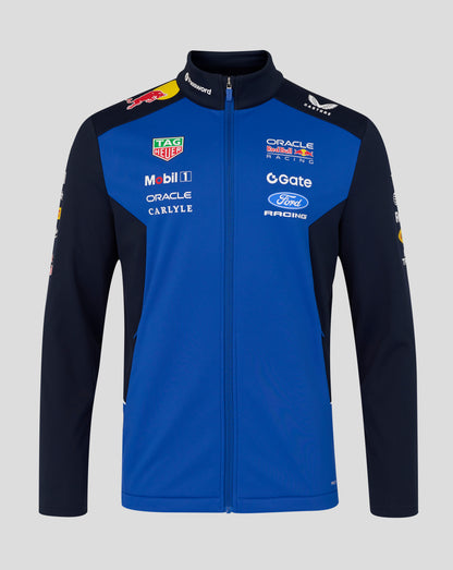 Front view of a model wearing a blue and navy Teamline jacket with multiple sponsor logos on the chest.