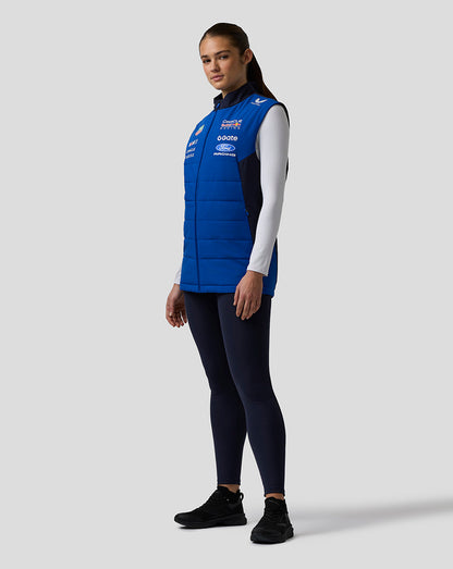 Profile view of a woman wearing a blue Oracle Red Bull Racing Teamline Gilet with sponsor branding.