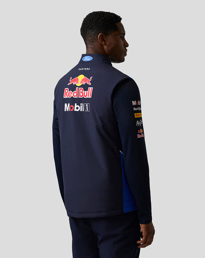 Back view of a man wearing a blue Teamline Gilet with a large Red Bull logo and sponsor branding.