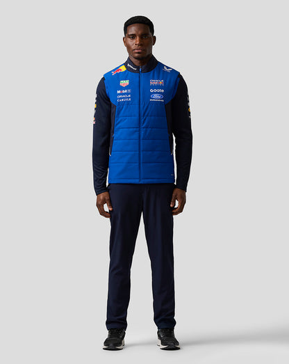 Front view of a person wearing the navy and bright blue Oracle Red Bull Racing Teamline Gilet with sponsor logos on the chest.