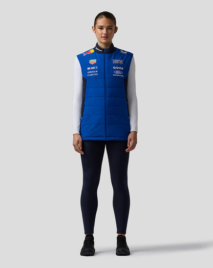 Front view of a female model wearing a bright blue Oracle Red Bull Racing Teamline Gilet with sponsor logos.