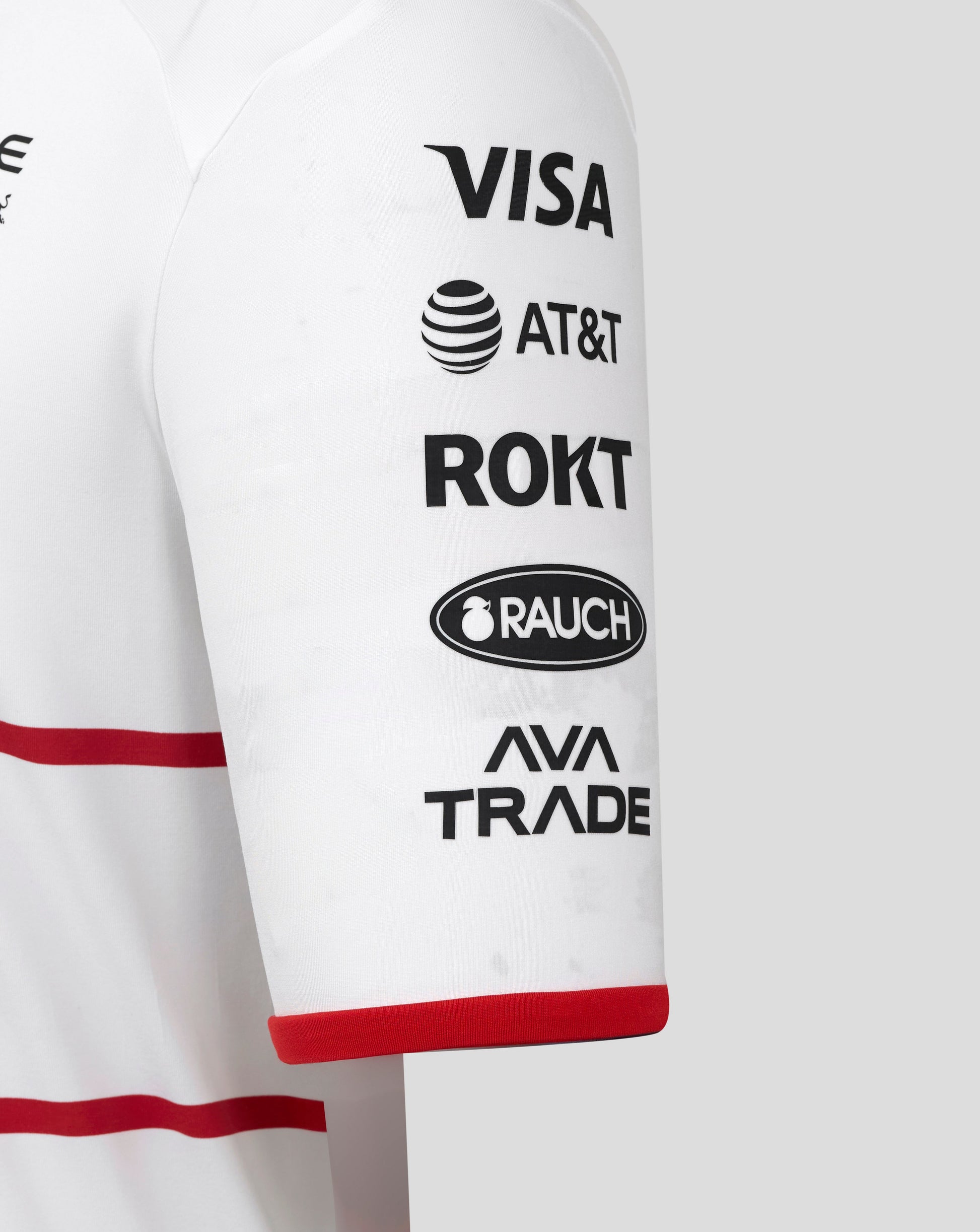 Sleeve of white Oracle Red Bull Racing track polo adorned with sponsor logos including VISA AT&T ROKT and RAUCH with a red cuff