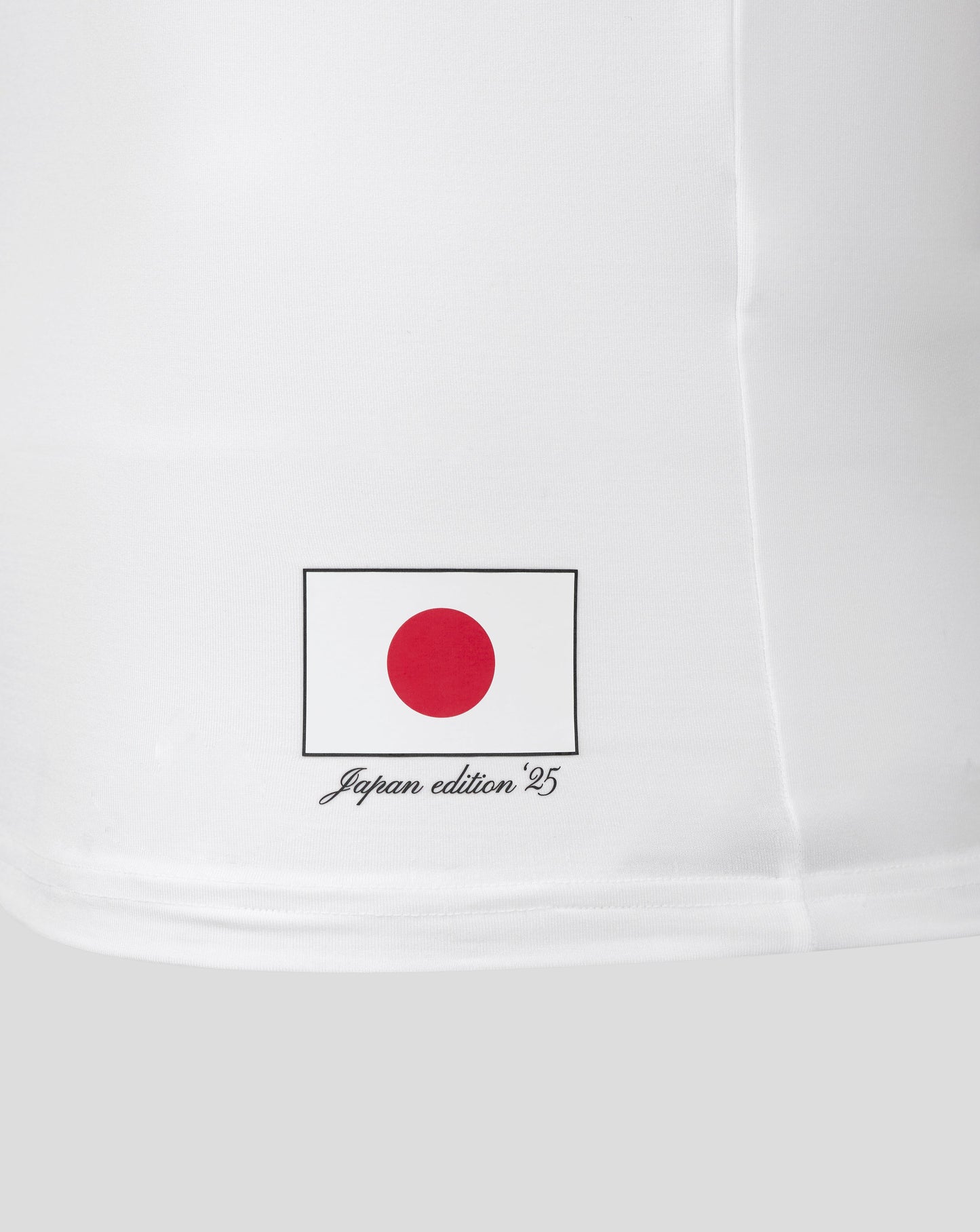 Japan edition badge with red circle on white background near the lower hem of the polo sleeve
