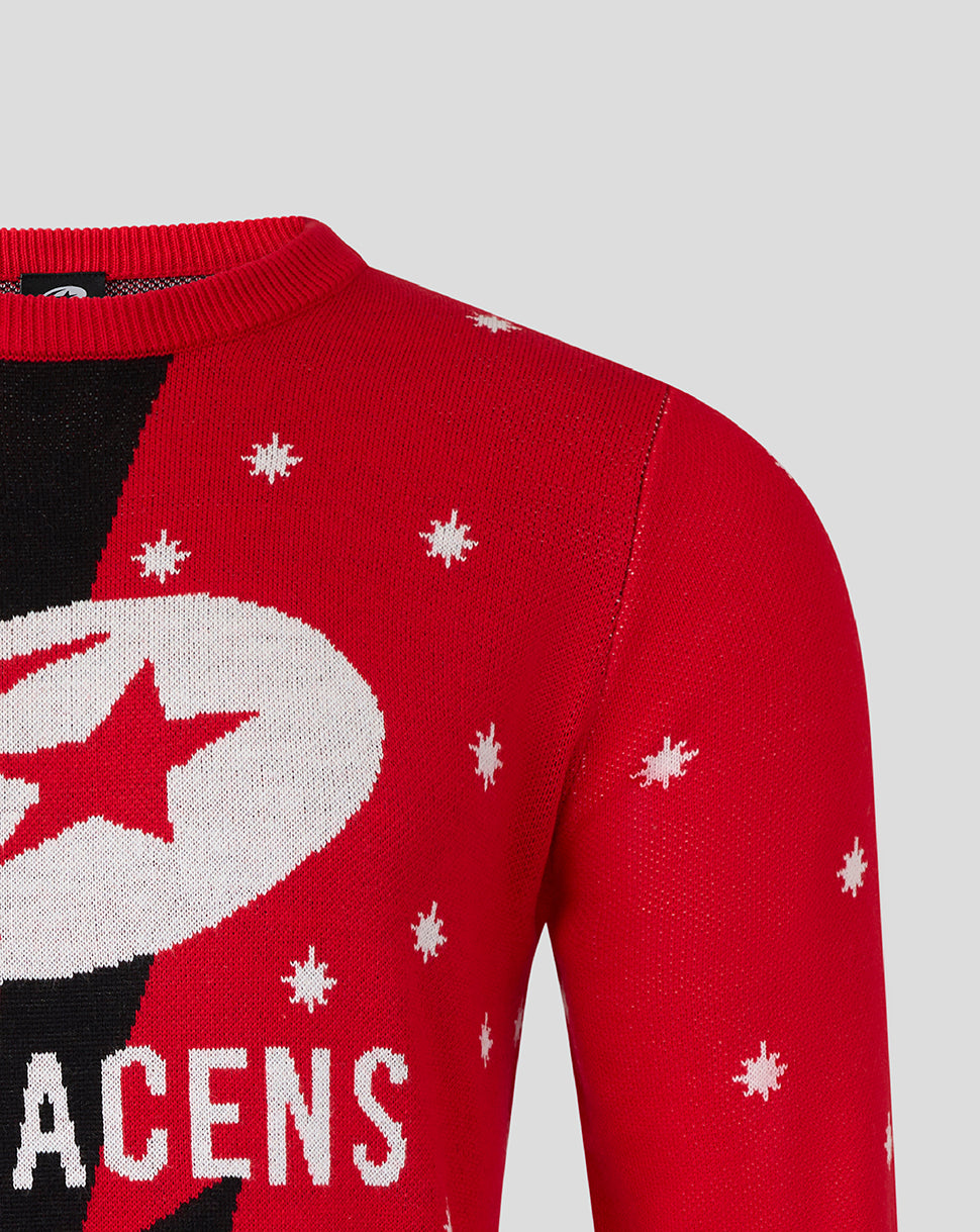 Front view of red Christmas jumper with a large white circular emblem featuring a red star and scattered snowflakes
