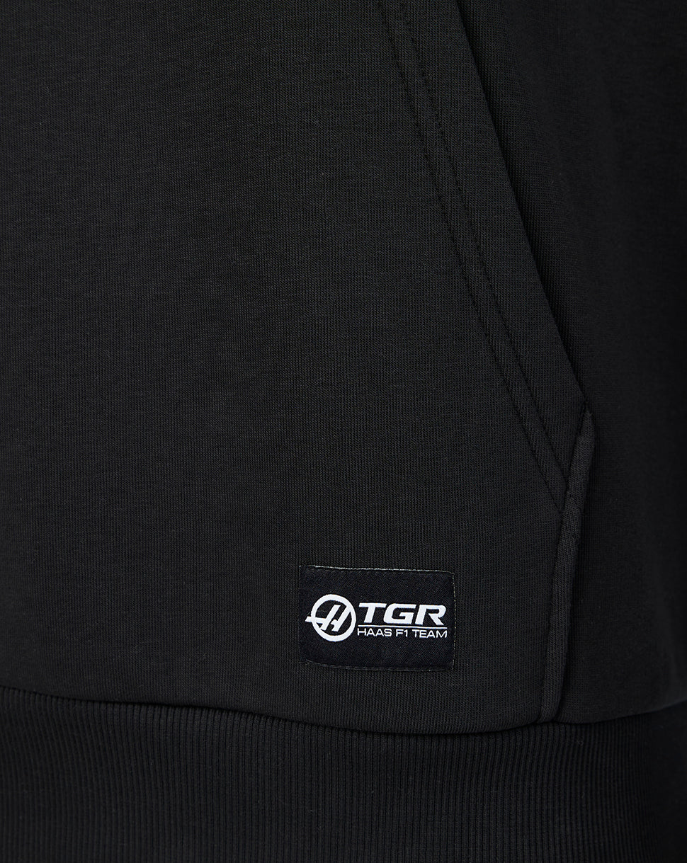 Close-up of the lower front pocket with a small TGR Haas F1 Team label stitched at the hem.