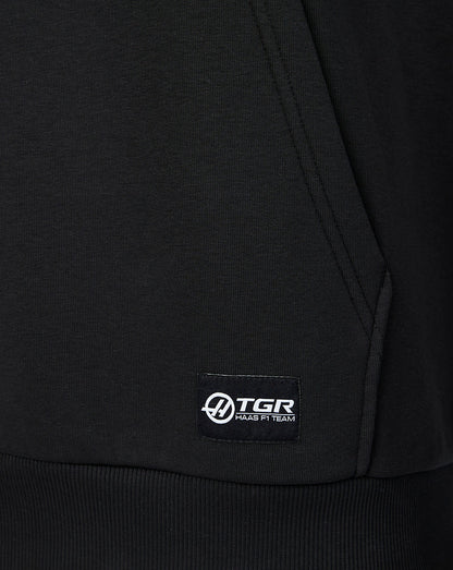 Close-up of the lower front pocket with a small TGR Haas F1 Team label stitched at the hem.
