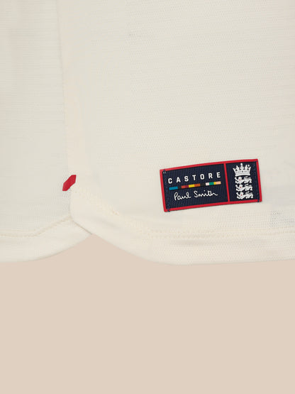 Hem detail of white knit T shirt with a Castore Paul Smith patch and crest on the lower front