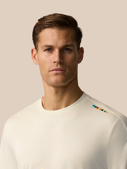 Male model wearing cream jacquard knit T shirt with multicolor shoulder stripe from Paul Smith Castore England Cricket collection