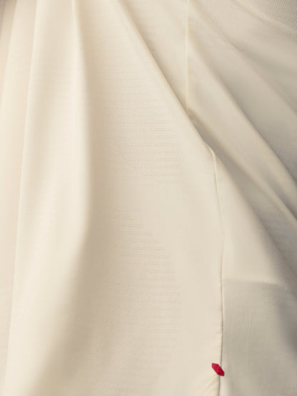 Close up of white knit T shirt showing Castore Paul Smith label sewn at the hem
